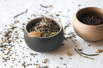 Fototapeta na wymiar Two cups with dry tea leaves, herbal and blsck tea. 