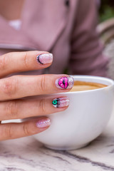 nail art manicure with colorful polish nails and cup of coffee. Beauty hands and stylish nails.