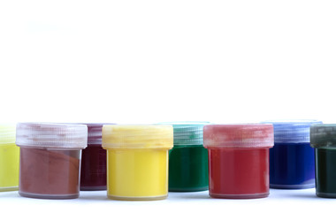 multi-colored cans of gouache in a row on a white background