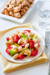 Salad with three kinds of tomatoes, boiled white kidney beans and croutons from white bread