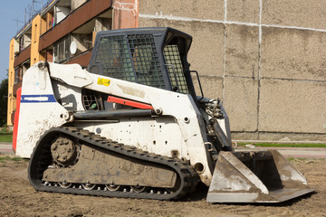 A Mini excavator bobcat standing at construction site