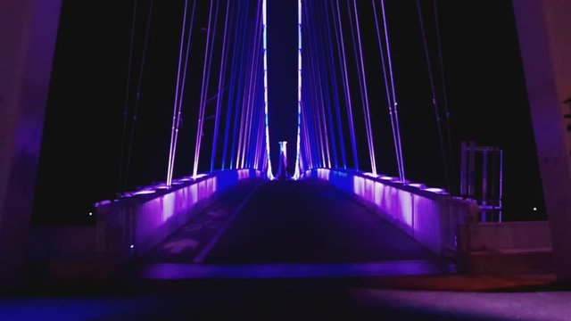 Front view of a colorful modern pedestrian bridge. Night in Osijek, Croatia. Seamless, Full HD.