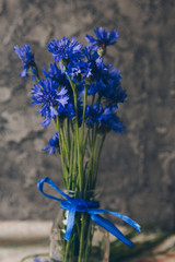 Seasonal summer flowers blue cornflowers and fruits strawberries on a napkin close-up conceptual background