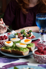 A light summer dinner for two: salad, boiled eggs, raspberries for dessert and white wine.