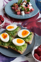 A light summer dinner for two: salad, boiled eggs, raspberries for dessert and white wine.