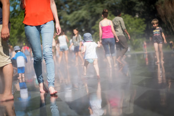 Vue d'un enfant courant sur le miroir d'eau de dos