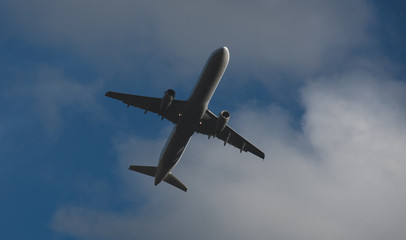 Fototapeta na wymiar Silhouette of a plane taking off against the blue sky