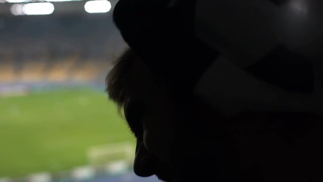 Emotional fan disappointed with team loss in football match at sports arena