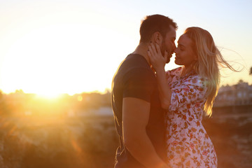 Fototapeta premium Love couple on rocks with sea view and sunset 
