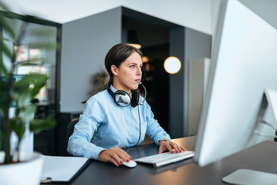 Beautiful Female Support Center Agent Looking At Monitor.