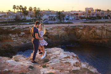 Love couple on rocks with sea view and sunset 