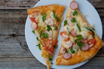Fresh baked homemade pizza with cheese and tomatoes. Rustic wooden background.