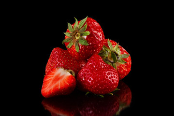 Macro image of fresh red strawberries group isolated at black background with reflection.