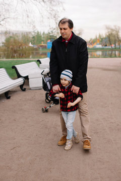Father helping to walk to his son with infant cerebral paralysis