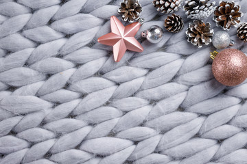 Christmas wooden decor on gray background with cones, toys, balls and woolen plaid