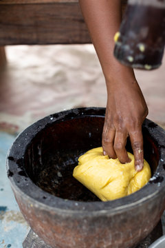 Person using a mortar and pestle to mix dough as part of a meal