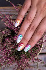 nail art manicure with colorful polish nails and purple flowers. Beauty hands and stylish nails.