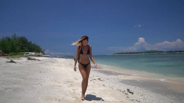 Outdoor shot of beautiful sexy woman walking on the beach