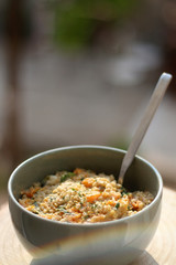 Bowl of bulgur wheat, roasted pumpkin, feta cheese and parsley salad. Selective focus, intentional lens flare.