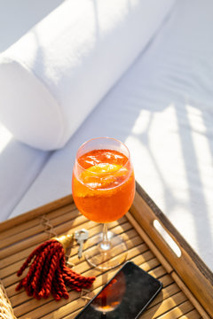 A drink on a tray table by a bed