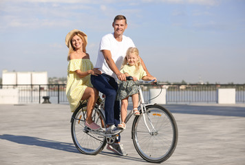 Obraz premium Happy family riding bicycle outdoors on sunny day