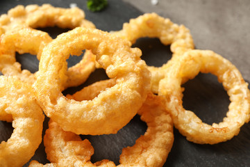 Homemade crunchy fried onion rings on table, closeup