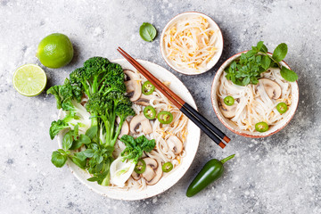 Vegetarian traditional Vietnamese soup Pho bo with herbs, rice noodles, broccolini, bok choy, bean sprouts, mushrooms. Vietnam national dish. Asian food concept.