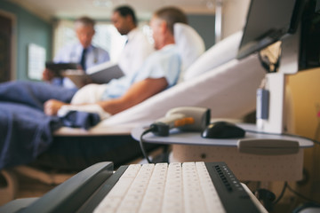 Hospital: Focus On Computer Keyboard WIth Doctors And Patients B