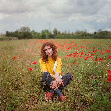 A beautiful redhead woman in a field of poppies