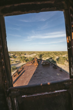 view through a window of a rusting abandoned trawler in former aral sea