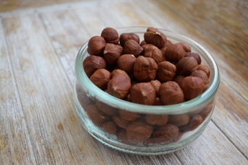 Hazelnuts in a glass jar in the background of the tree. Copy space.