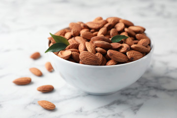 Tasty organic almond nuts in bowl on table