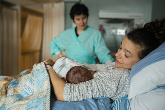 New Mother And Baby With Nurse In Background