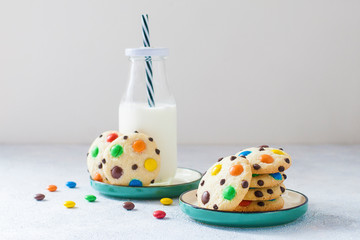 Homemade cookies with m&m's and chocolate with bottle of milk. Copy space.
