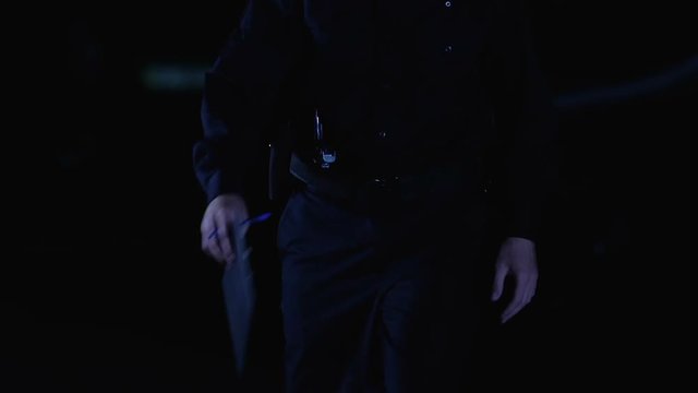 Policeman filling documents at crime scene, walking to car and opening door