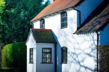 Closeup of An old typical traditional English country house with white wall in a forest