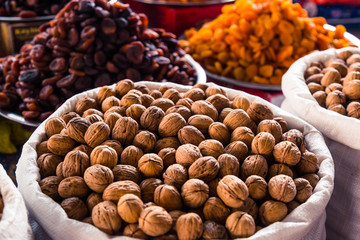 Many walnuts lie on the market and in the store. Open and peeled nuts are full of vitamins, a fresh...