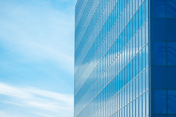 Closeup of A glassy building office with too many windows with blue sky