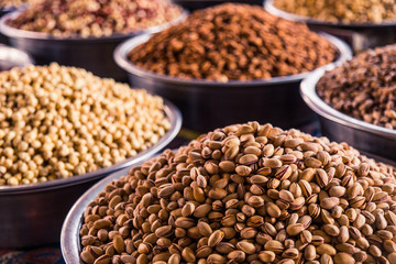 A mixture of nuts on the market. Various nuts in the store, juicy snacks sold in the market. Food for vegetarians. Ingredient for cooking and sweets. 