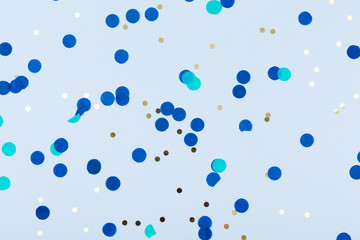 Blue background with gold and dark blue confetti. Christmas and Hanukkah, holiday concept.