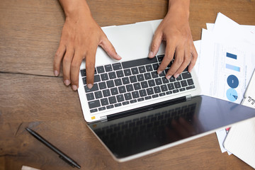 Fototapeta na wymiar businessman hand working on blank screen laptop computer on wooden desk as concept