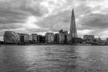 Fototapeta premium Southwark under dramatic clouds, black and white Thames in London.