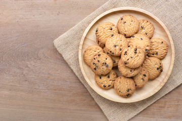 top view of chocolate butter cookies in a dish on wooden table with copy space.