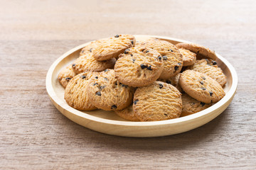 close up of chocolate butter cookies in a dish on wooden table.