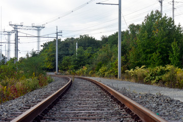 Fototapeta na wymiar Steel rail road tracks over crushed stones, disappearing in the distance (3)