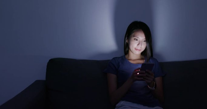 Woman use of cellphone at home in the evening