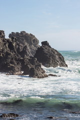 Fototapeta na wymiar Close up image of waves crashing into rocky outcrops along the Cape Palliser coast of New Zealand.