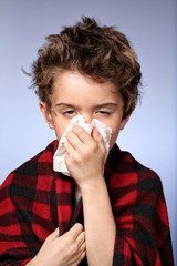 Kid with cold covering with a blanket