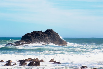 Close up image of waves crashing into rocky outcrops along the Cape Palliser coast of New Zealand.