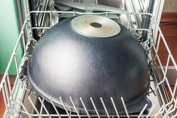 Large black cauldron lies in the lower compartment of the dishwasher